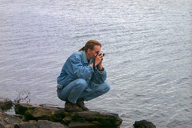 Picture of Imke kneeling at the water, taking a picture