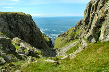 Picture of a deep cut into cliffs, the sea below