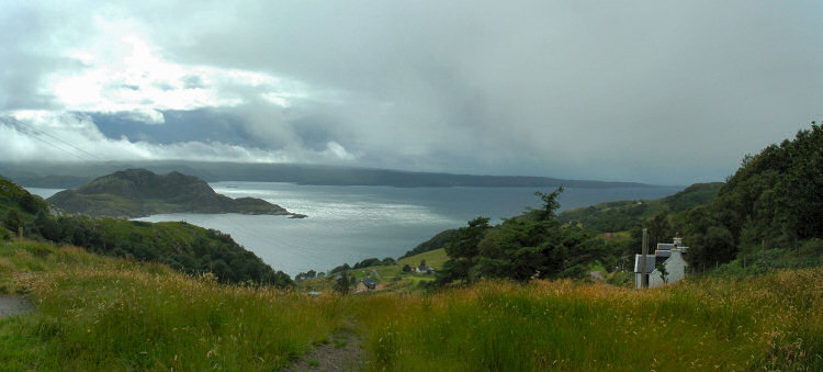 Picture of a view over a sea loch, the sun breaking through but more rain coming in