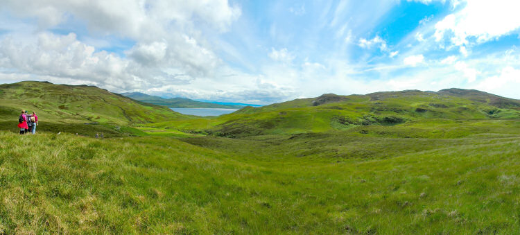 Picture of a panoramic view over a wide glen with a sound between two islands at the end