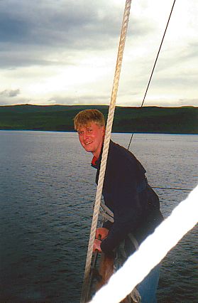 Picture of a man standing on the upper yard of a tall ships mast