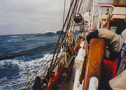 Picture of a wave crashing, seen from a tall ship