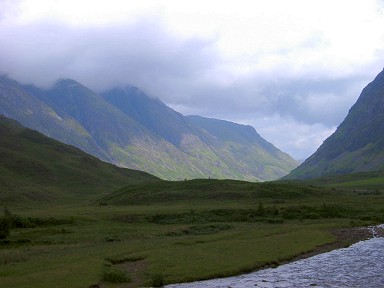 Picture of a glen with some sun breaking through, but low clouds above