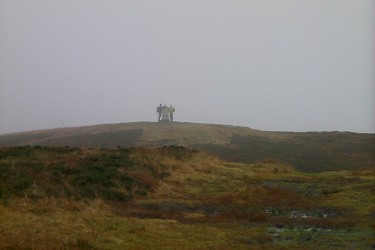Picture of a trig point on a hill, hazy and grey weather