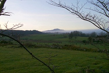 Picture of a view over a landscape in the evening sun, low fog in the distance