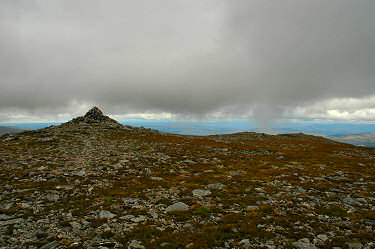Picture of a cairn with clouds low above it