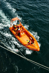 Picture of a boat with a crew member catching a rope