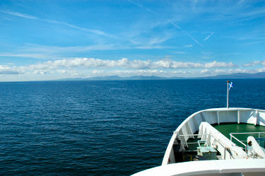 Picture of an island in the distance, seen over the ships bow