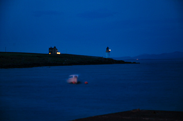 Picture of a boat and a lighthouse in the dark