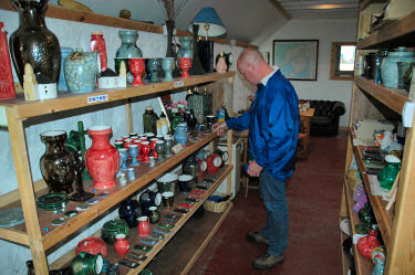 Picture of a man looking at pottery on shelves