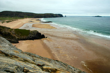 Picture of a sandy beach in a bay with low tide approaching