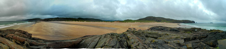 Panoramic view of a beach and dunes behind a bay