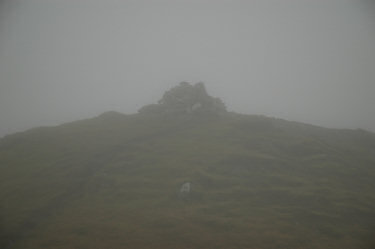 Picture of a cairn and trigpoint in the clouds