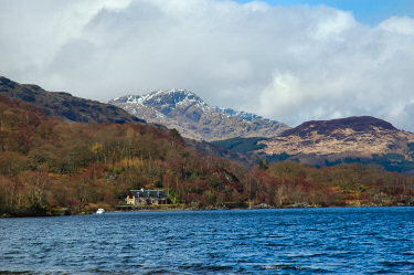 Picture of hills with a little bit of snow over a loch