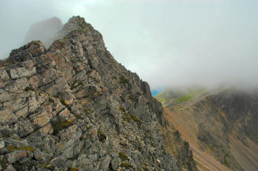 Picture of some steep mountain cliffs under some low clouds