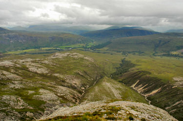 Picture of a view down a ridge into a glen with a village