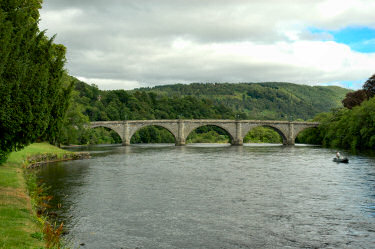 Picture of a view over a river, an arch bridge in the distance