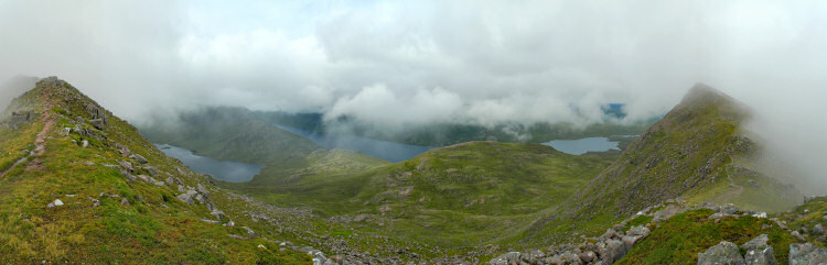 Picture of a panoramic view from a mountain ridge over two lochs, low clouds just above