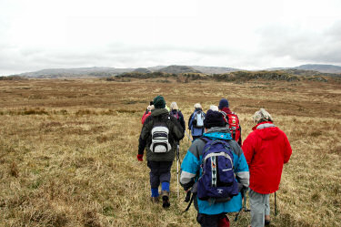 Picture of a group of walkers on their way to some low hills