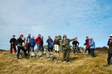 Picture of walkers standing at the ruins of an old cottage (Sornasairidh), guide pointing out something