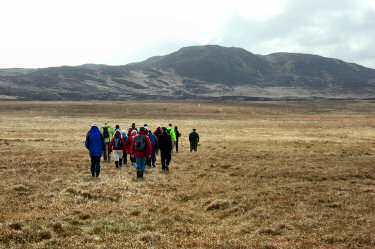 Picture of walkers on a wide open plain, hills in the background