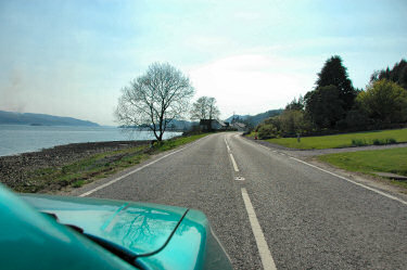 Picture of a road along a sea loch as seen from a car