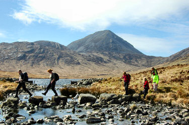 Picture of walkers crossing a burn over some boulders