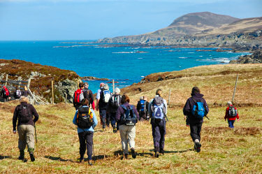 Picture of walkers going along a rocky shoreline