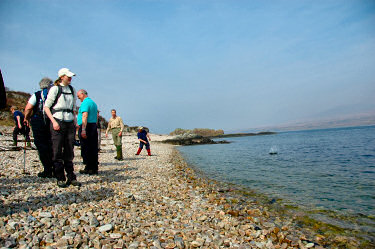 Picture of people skimming stones on a pebble beach