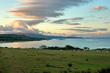 Picture of a bay in the evening light, nice cloud formations above