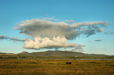 Picture of an impressive cloud formation above some low hills near the top of a loch