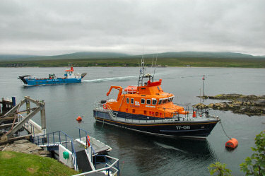 Picture of a RNLI lifeboat at its mooring and a small ferry in the background