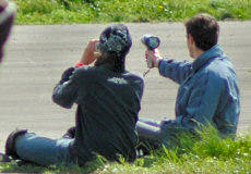 Picture of two people, one holding a speed gun